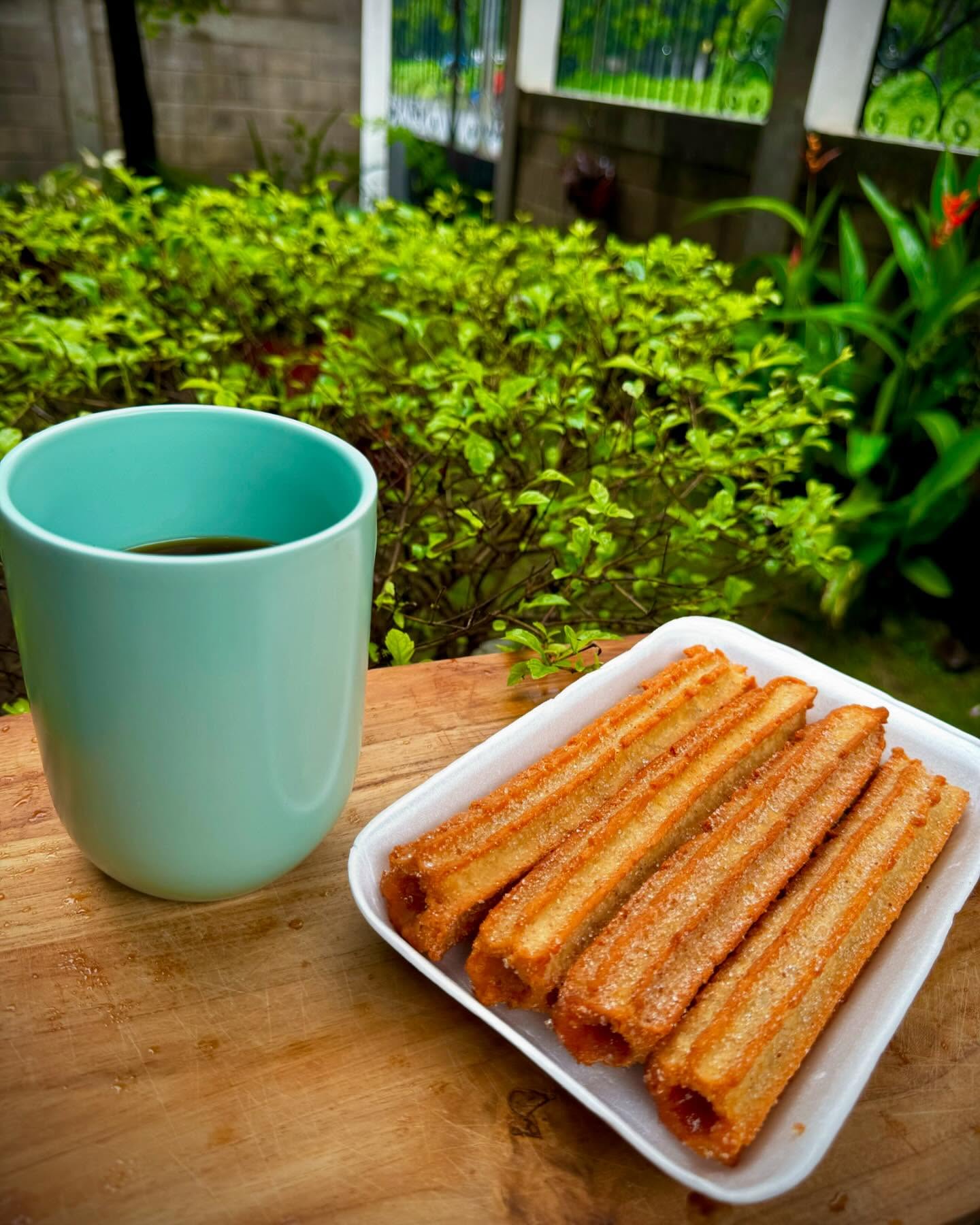 Churros clásicos con azúcar y canela junto a un café
