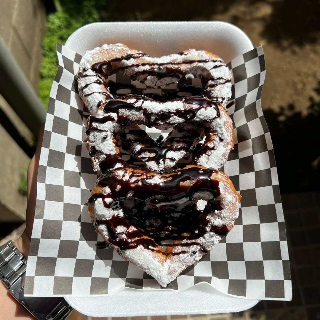 Churros en forma de corazón con azúcar glas y chocolate