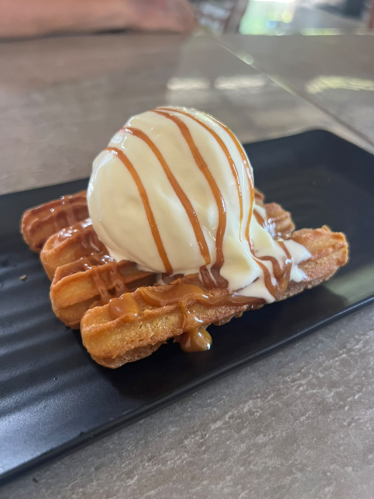 Churros con una bola de helado de vainilla y caramelo