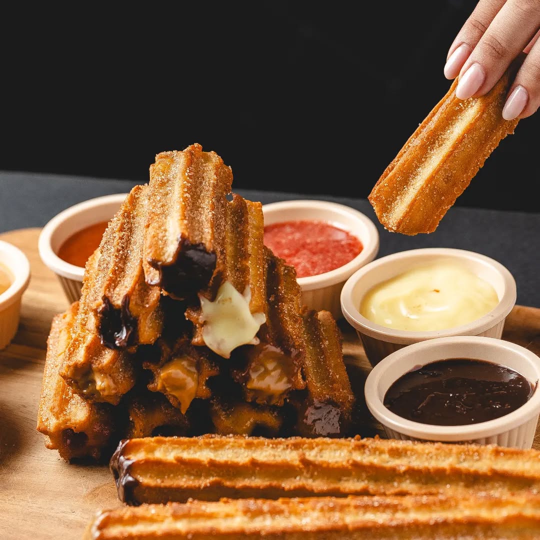 Torre de churros rellenos con salsas de chocolate, vainilla y fresa